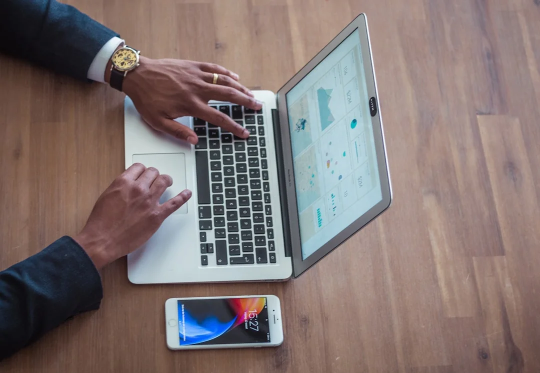 A diverse team collaborating on digital marketing strategies at a desk, using laptops and tablets.